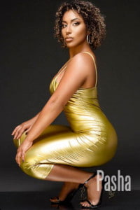Curly haired black girl in a gold silk dress