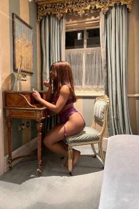 Sexy black girl sitting at a dressing table in a luxurious room