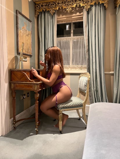 A black girl in luxcury lingerie sitting at a dressing table