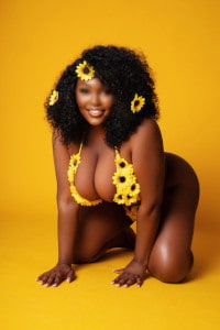 Extremely busty black girl in a yellow flower patterned bikini