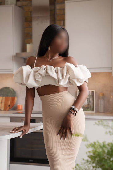 Slender ebony French woman in a white top and cream pencil skirt