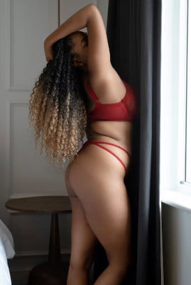 Curly haired curvy black girl striking a sexy pose