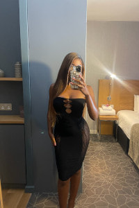 Hot ebony in a low cut black dress taking a selfie
